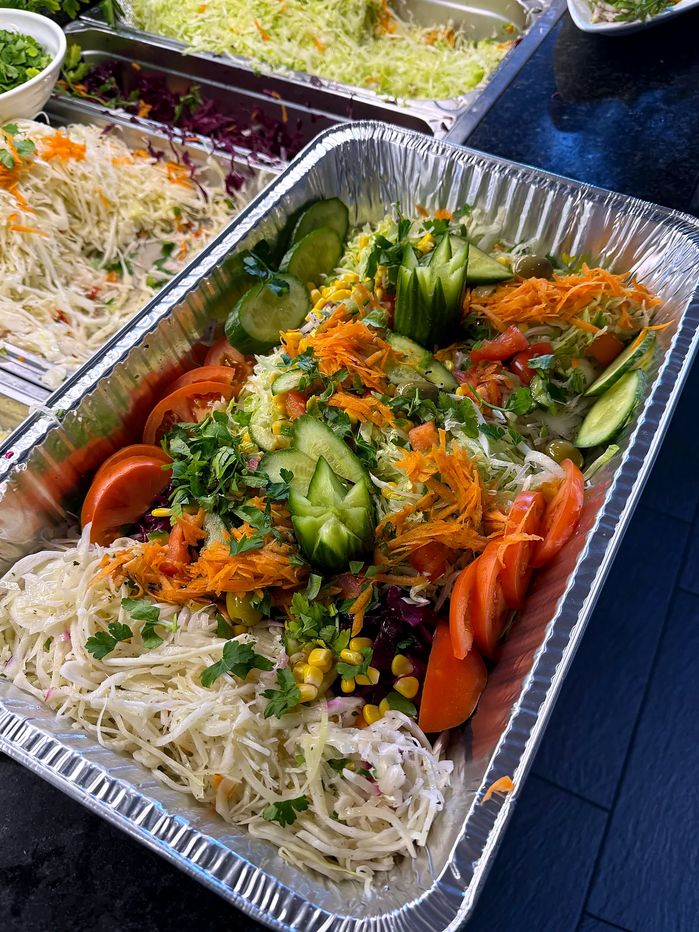 Frisches Salatbuffet mit Karotten, Gurken und Tomaten in Schalen