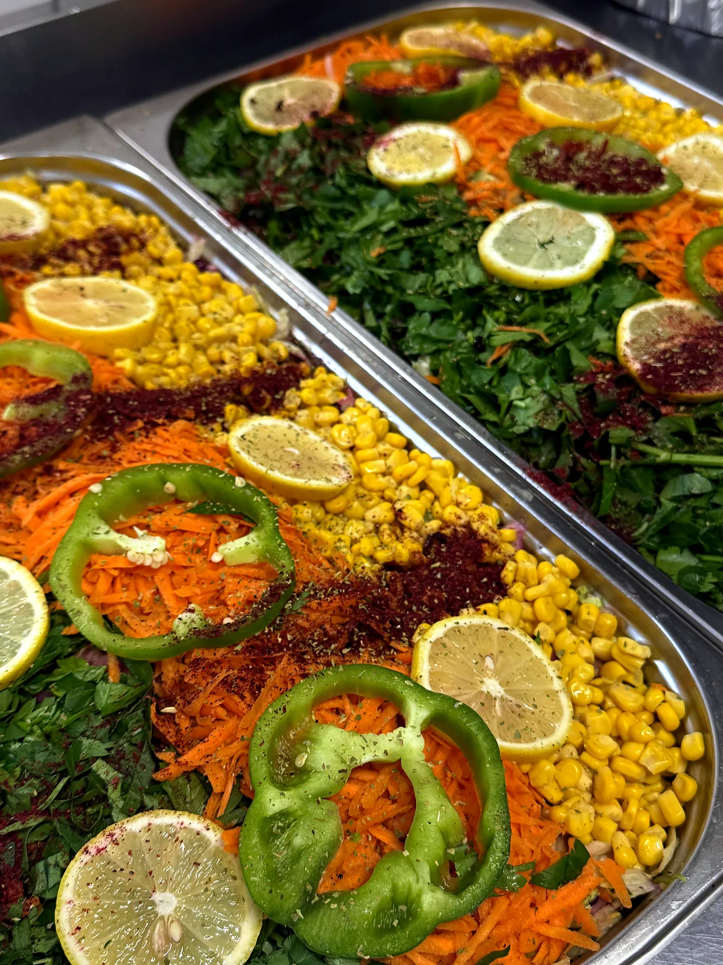 Bunte Salatplatte mit Mais, Paprika, Zitronen und Karotten