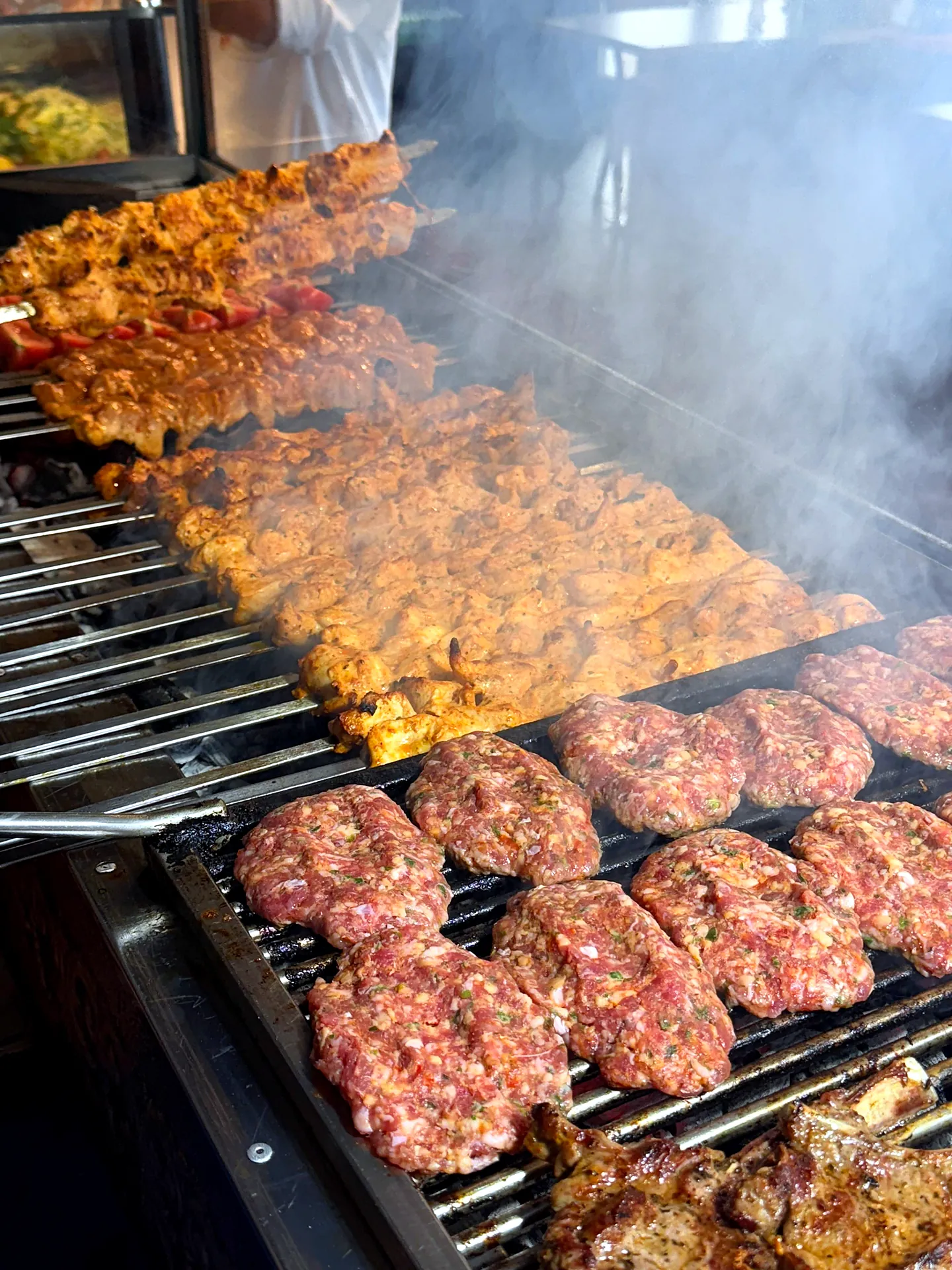 Köfte und Hähnchenspieße auf dem rauchenden Holzkohlegrill